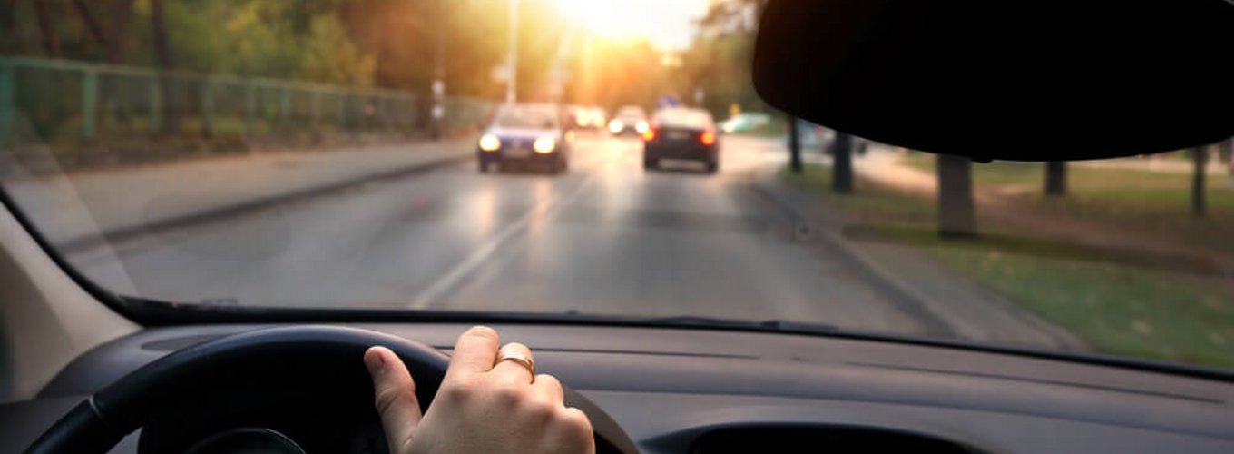 kierowca jedzie drogą w słoneczny dzień