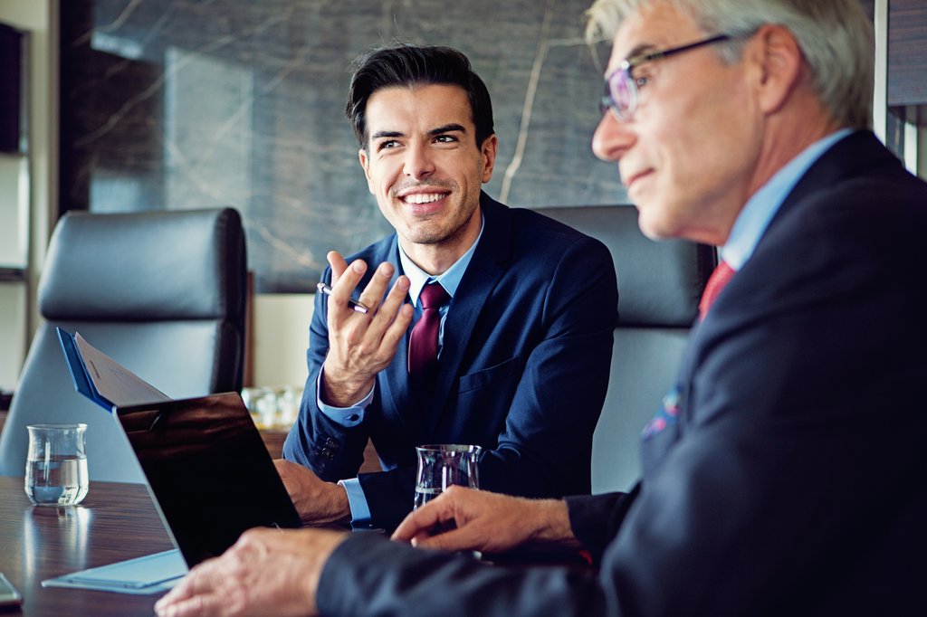 Mężczyźni rozmawiają podczas spotkania biznesowego w siedzibie uniqa