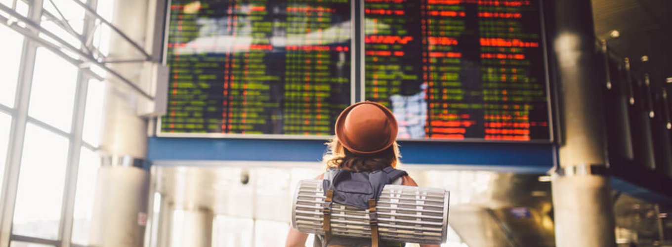 młoda dziewczyna sprawdza swój lot na tablicy odlotów