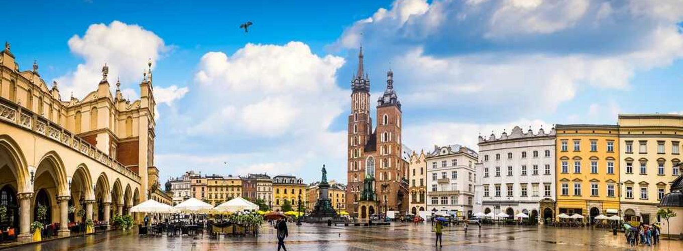 Widok historycznego Rynku Głównego w Krakowie, gdzie możesz uzyskać kartę EKUZ, na pierwszym planie charakterystyczna Bazylika Mariacka i Sukiennice. Widok historycznego Rynku Głównego w Krakowie, gdzie możesz uzyskać kartę EKUZ, na pierwszym planie charakterystyczna Bazylika Mariacka i Sukiennice.