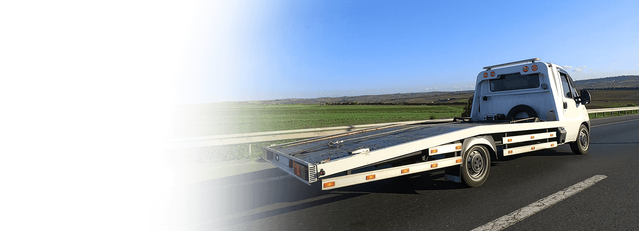 Biała laweta jadąca autostradą