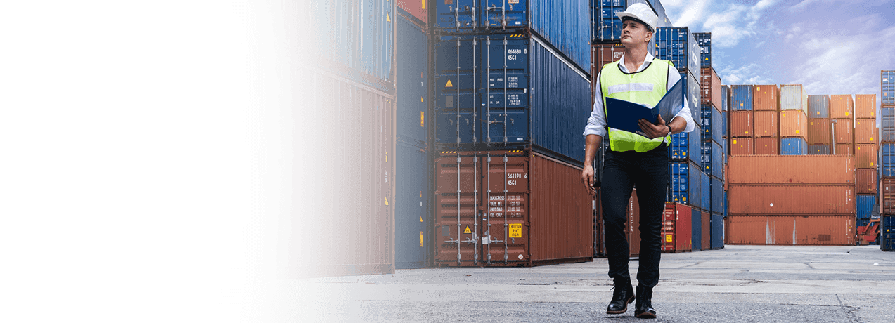 Mężczyzna w kamizelce odblaskowej stoi przed kontenerami transportowymi
