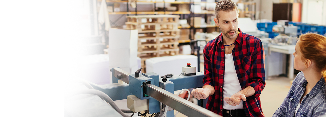 Mężczyzna rozmawiający z kobietą w fabryce o zaletach ubezpieczenia Ochrona z Plusem w UNIQA