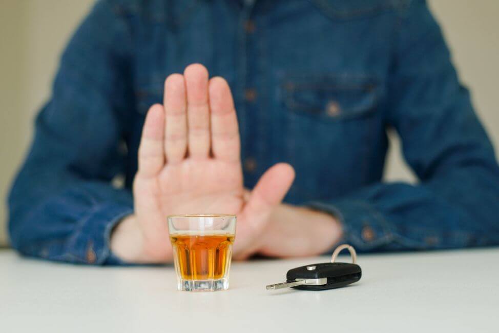 Mężczyzna odmawia napicia się alkoholu ponieważ będzie prowadził auto z blokadą alkoholową