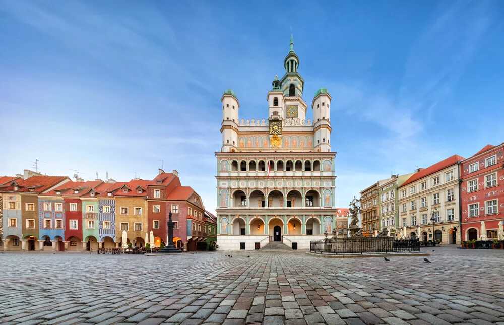 Rynek w Poznaniu z kolorowymi kamienicami i renesansowym ratuszem, idealny na spacer z karta EKUZ uprawniającą do korzystania z opieki zdrowotnej podczas podróży po krajach Unii Europejskiej.